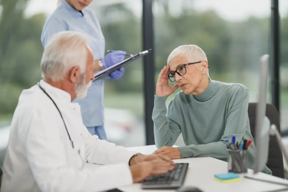 Médecin et patiente en consultation, échange posé autour d'un bureau
